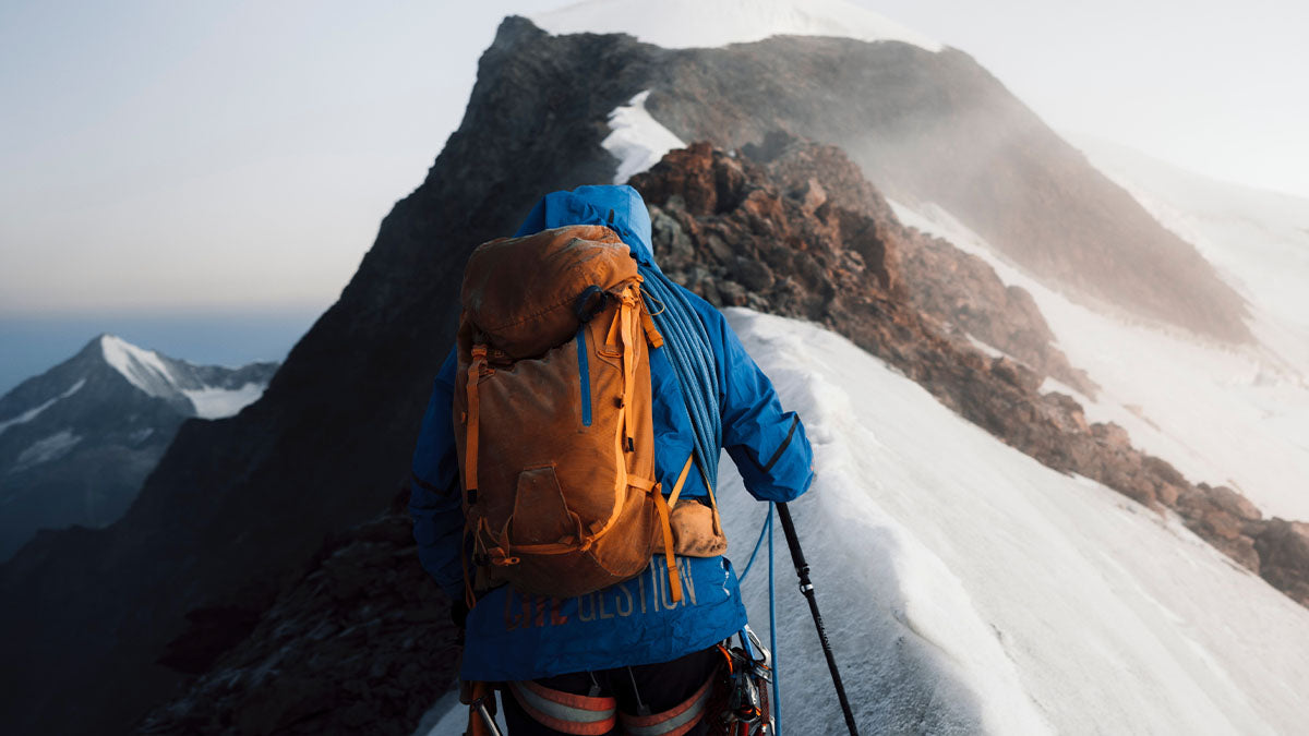 Person climbing a tall mountain.