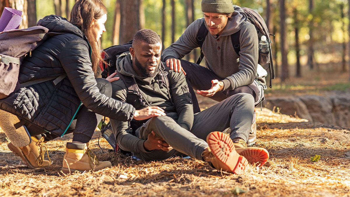 A man suffering from blisters resting on the trail.