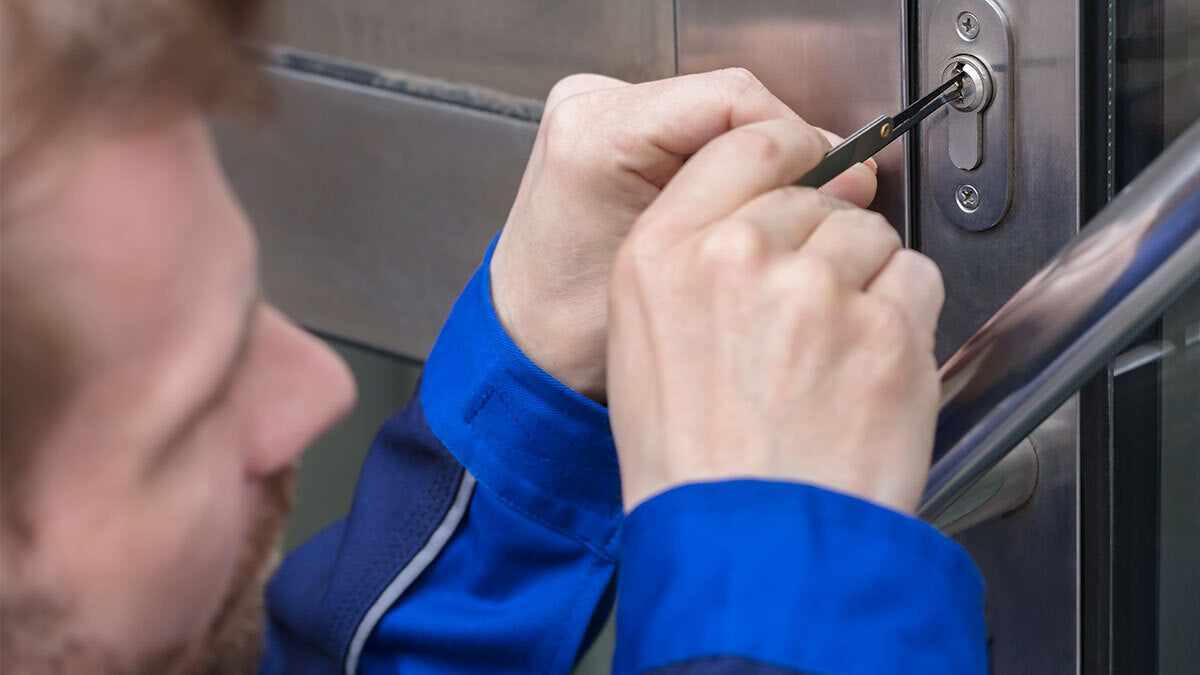 Man picking a lock on a door.