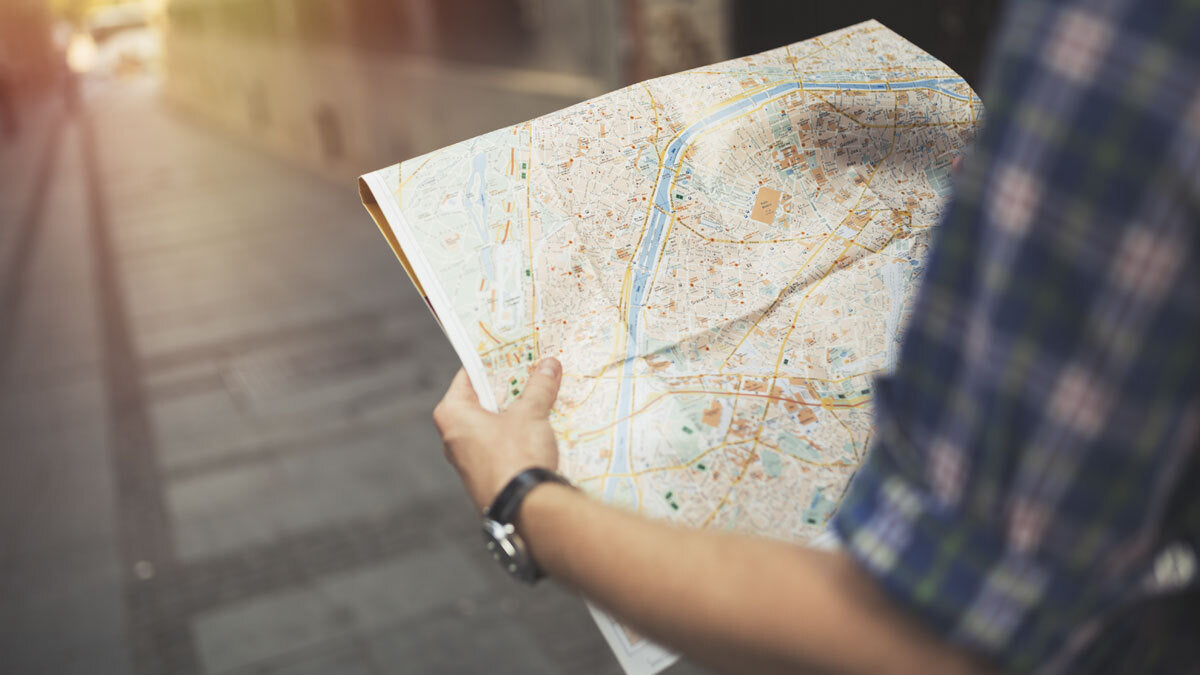 Person looking at a paper map on a street