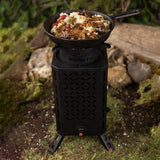 InstaFire Inferno Pro stove cooking food outdoors on a log.