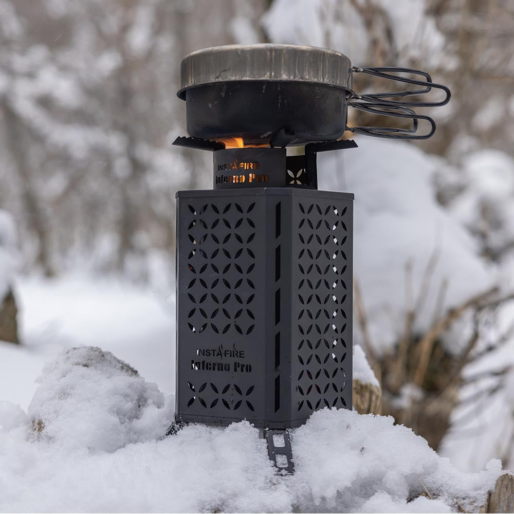 InstaFire Inferno Pro stove with a pot on top, operating in snowy conditions