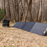 Grid Doctor 200W solar panel set up in an open field, connected to the compatible battery system, harnessing renewable energy in a natural setting.