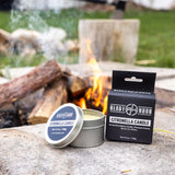 citronella candle by ready hour and packaging sitting next to a campfire